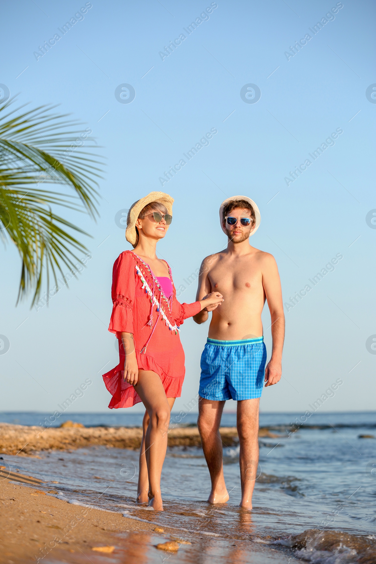 Photo of Happy young couple walking together on beach