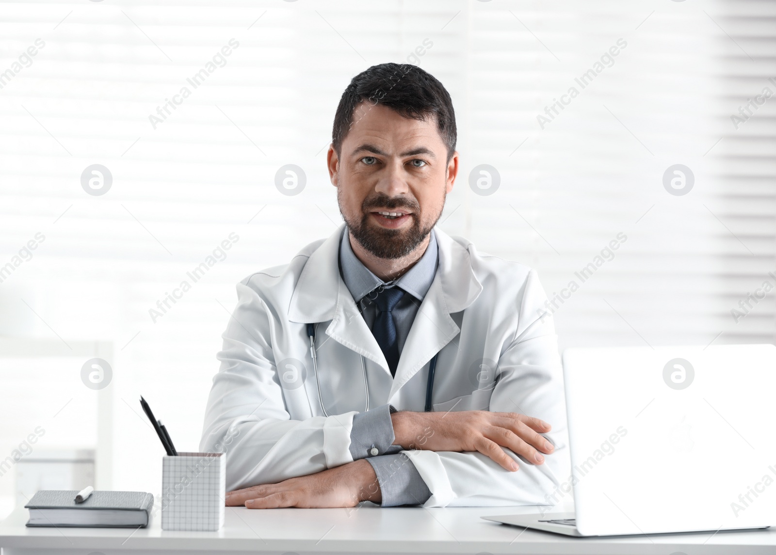 Photo of Portrait of male doctor in white coat at workplace