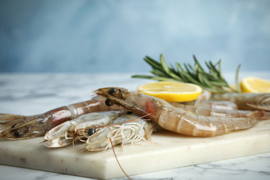 Photo of Fresh raw shrimps on marble table, closeup