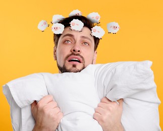 Exhausted man with pillow suffering from insomnia on yellow background. Illustrations of sheep running around his head