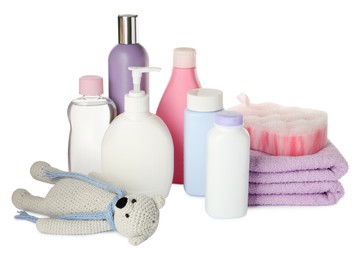 Bottles of baby cosmetic products, towels, bath sponge and toy bear on white background