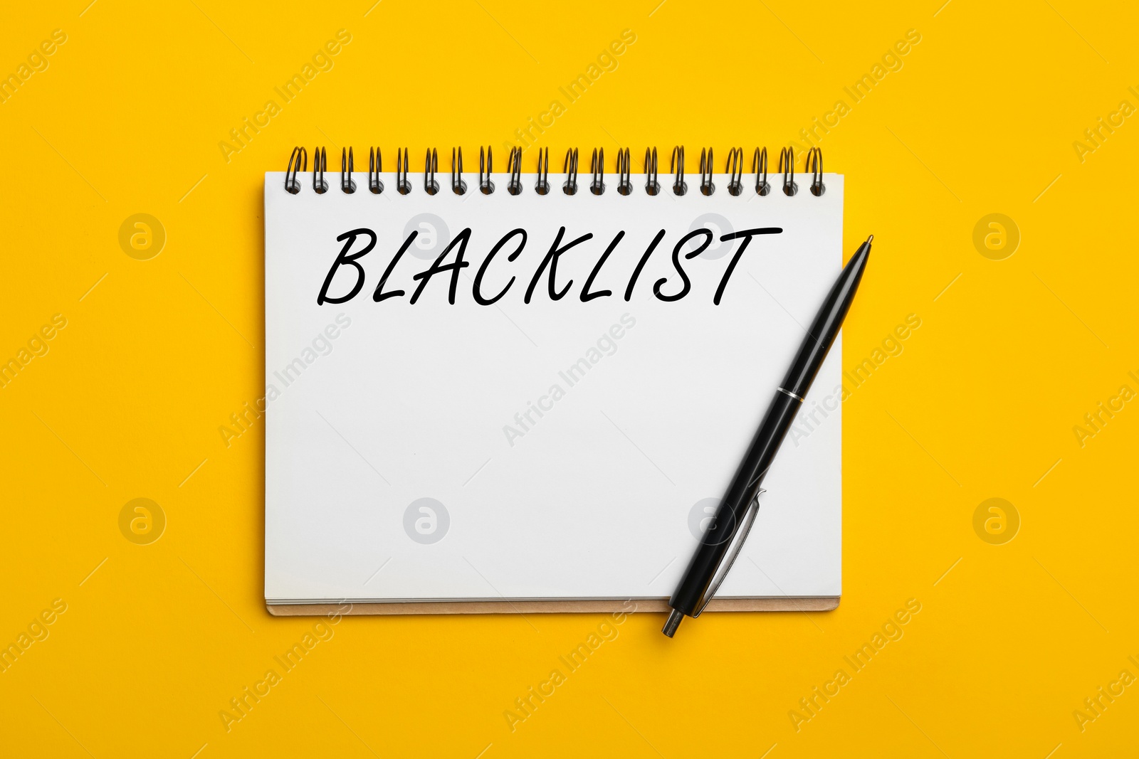 Image of Word Blacklist written in notepad on yellow background, top view