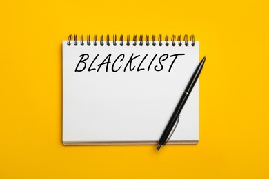 Image of Word Blacklist written in notepad on yellow background, top view