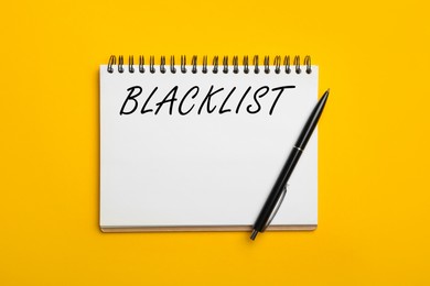 Word Blacklist written in notepad on yellow background, top view