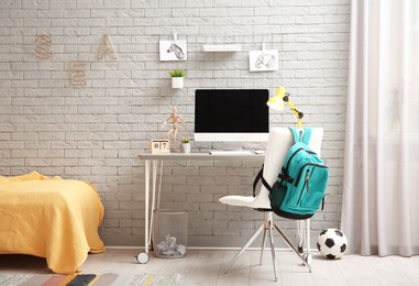 Photo of Comfortable workplace with modern computer in child room