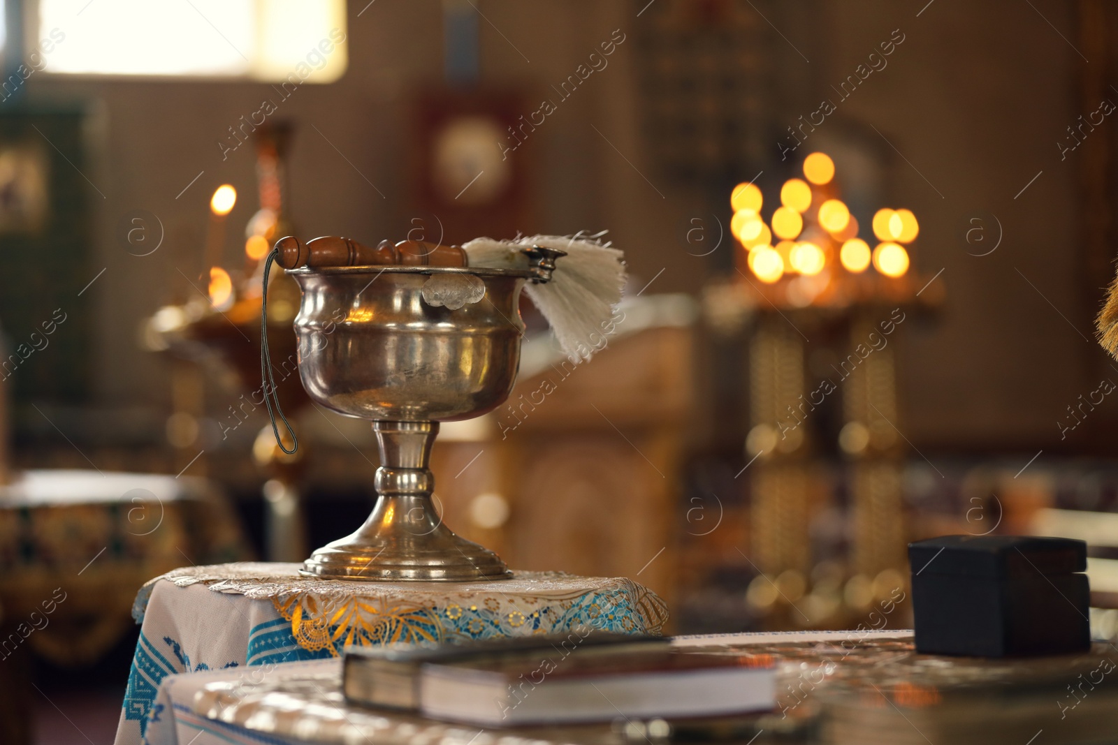 Photo of Silver vessel with holy water and brush on stand in church, space for text. Baptism ceremony