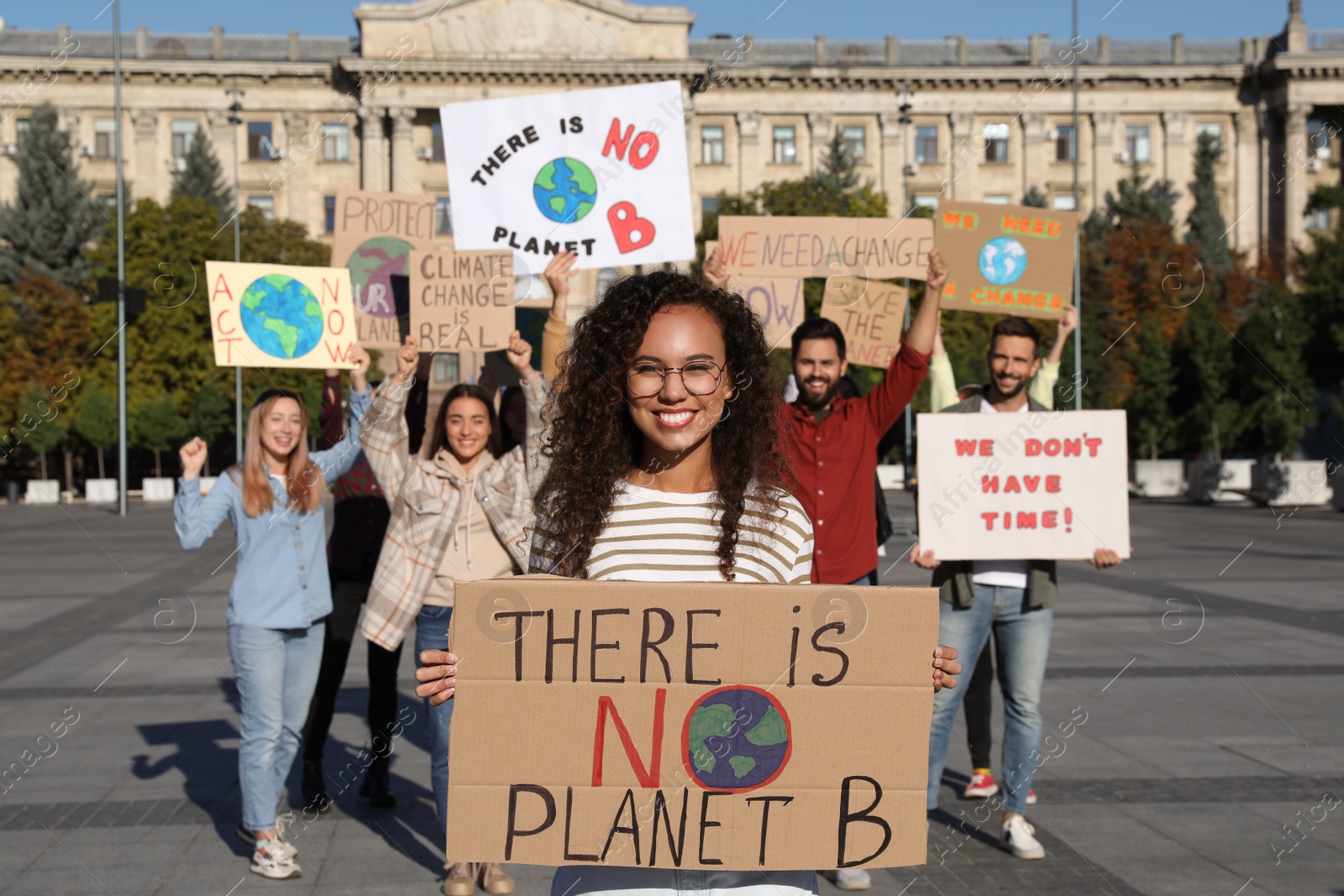 Photo of Group of people with posters protesting against climate change on city street