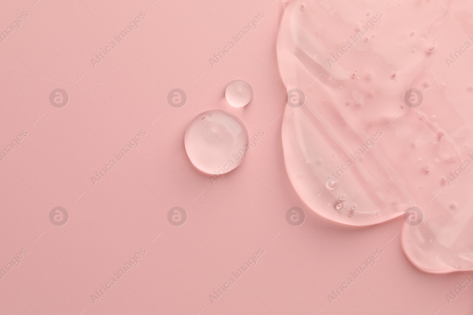 Photo of Clear cosmetic gel on pink background, top view. Space for text