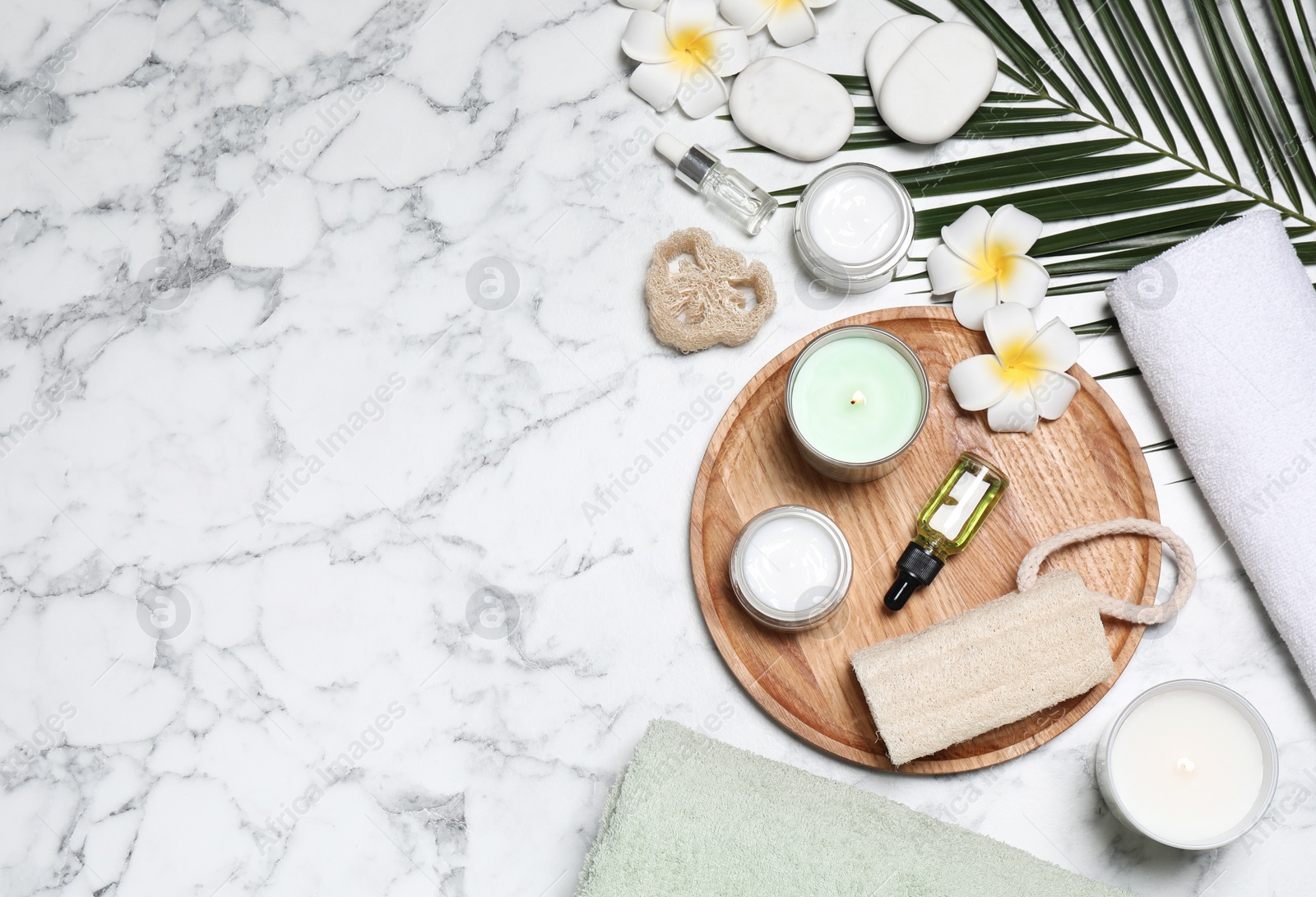 Photo of Flat lay composition with spa essentials on white marble background. Space for text