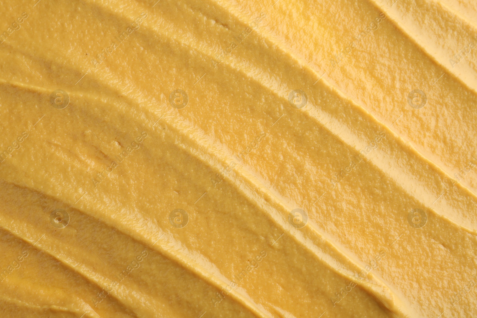 Photo of Fresh tasty mustard sauce as background, top view