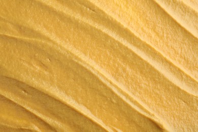 Photo of Fresh tasty mustard sauce as background, top view