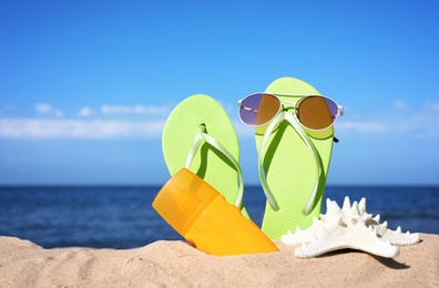 Composition with beach accessories on sand near sea in summer