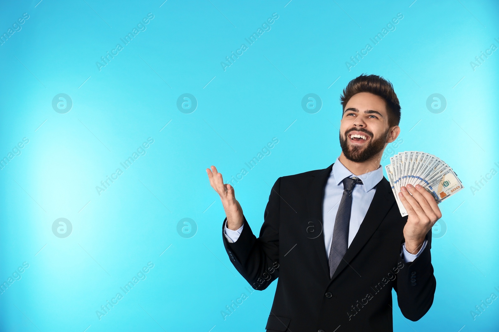 Photo of Portrait of happy young businessman with money on color background. Space for text