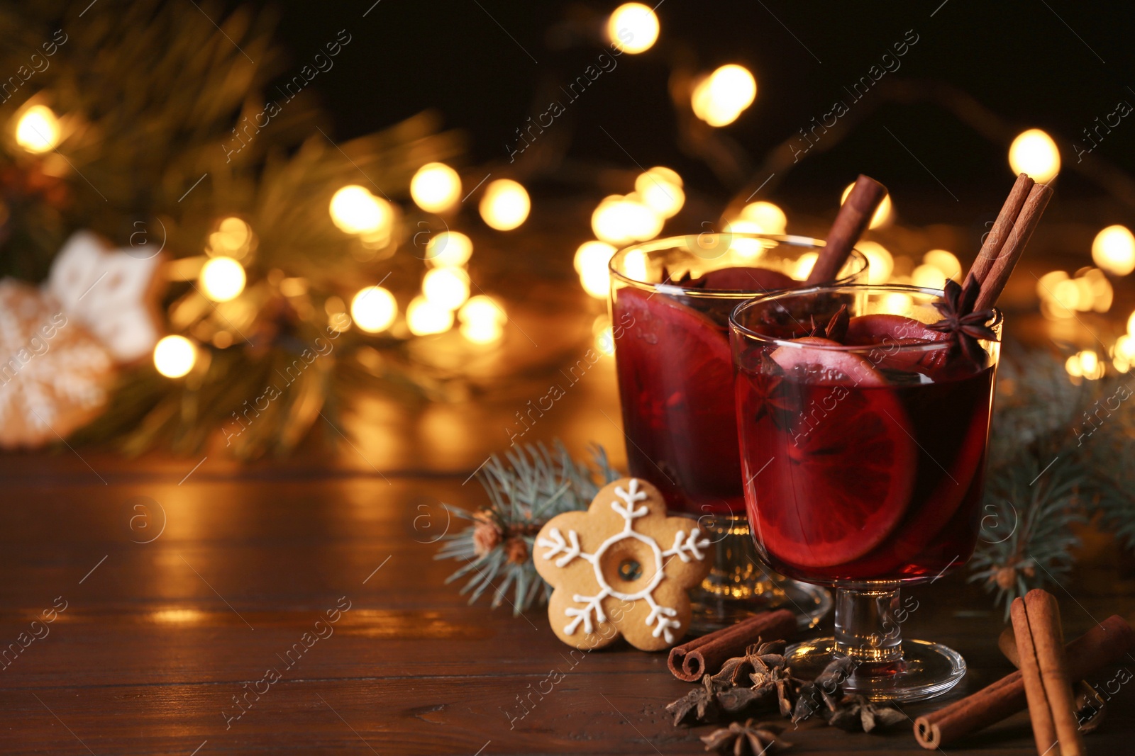 Photo of Mulled wine with cinnamon, anise and orange on table. Space for text
