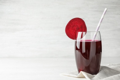 Photo of Glass of beet juice on table against light background. Space for text