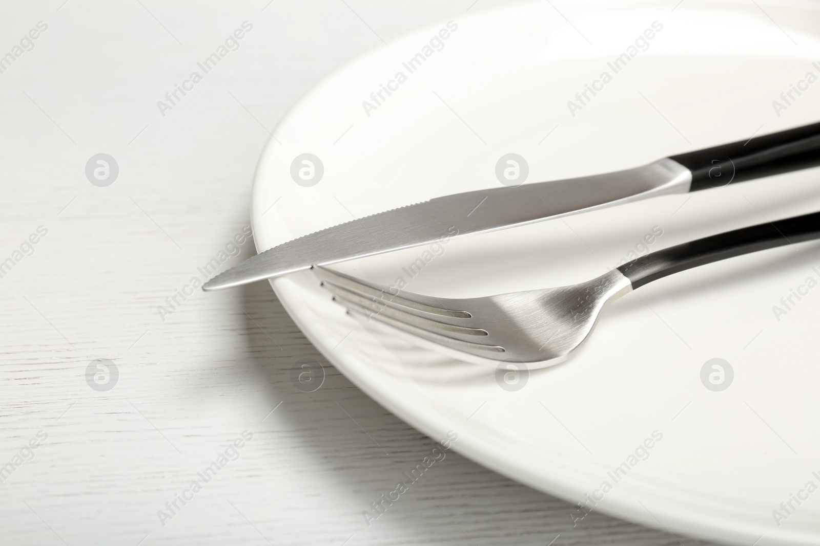 Photo of Plate with fork and knife on table, closeup. New setting