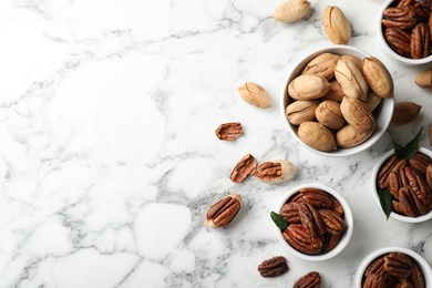 Flat lay composition with tasty pecan nuts on marble table. Space for text