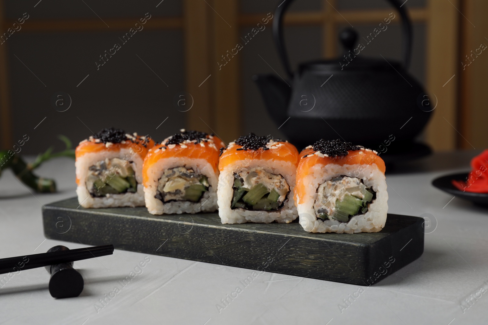 Photo of Delicious sushi rolls served on light grey table