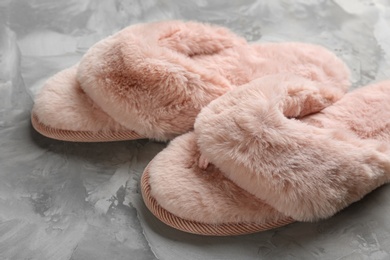 Pair of stylish soft slippers on grey background, closeup