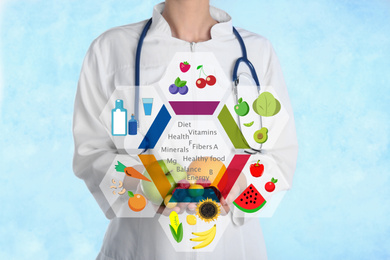 Nutritionist's recommendations. Doctor with healthy products on light blue background, closeup