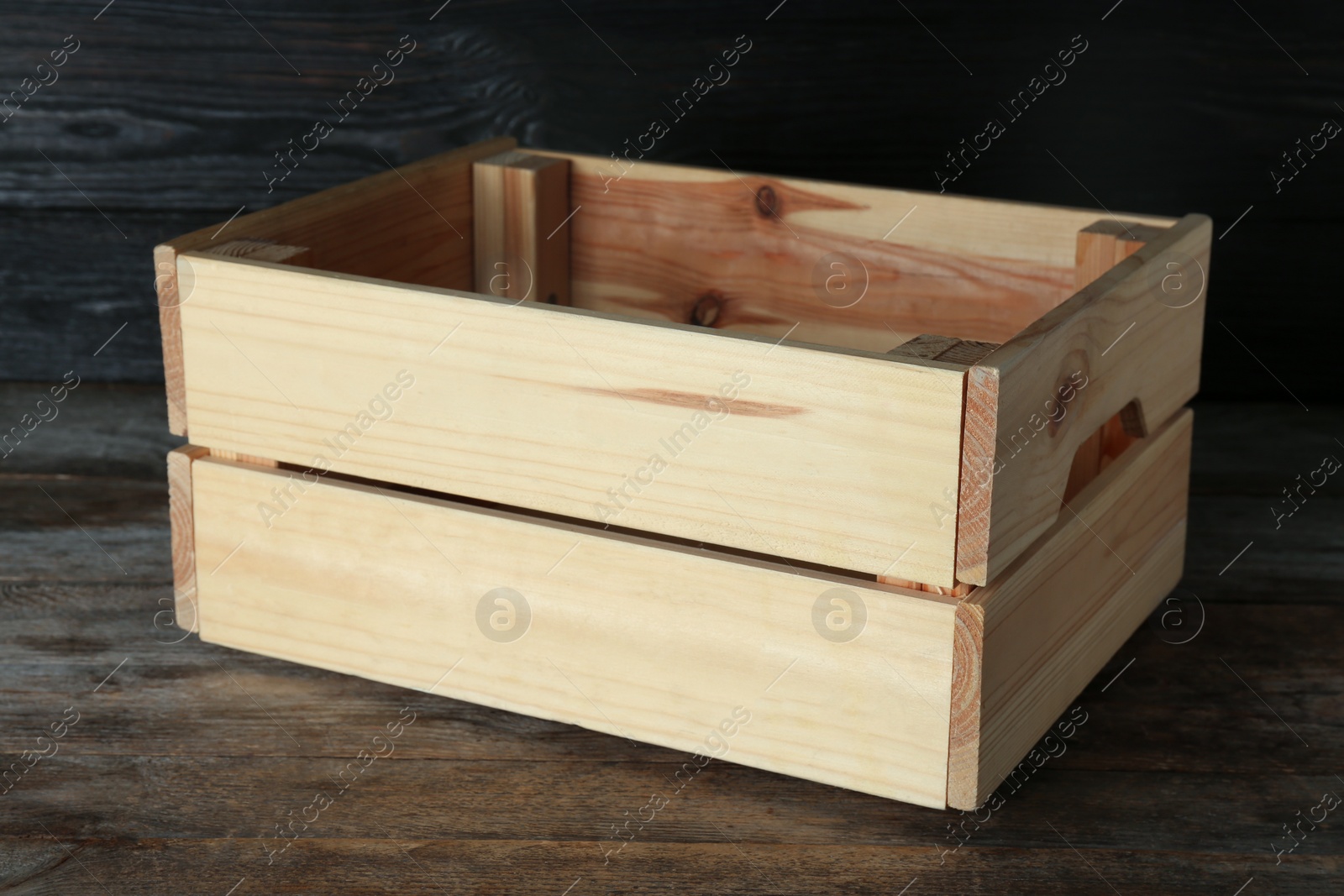 Photo of Wooden crate on table against dark background