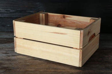 Photo of Wooden crate on table against dark background