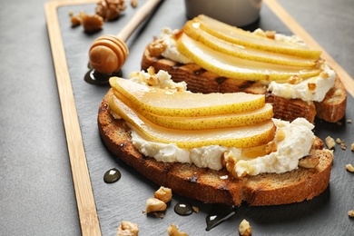 Photo of Toasted bread with cream cheese and pear on board