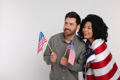 Photo of 4th of July - Independence Day of USA. Happy couple with American flags on white background, space for text
