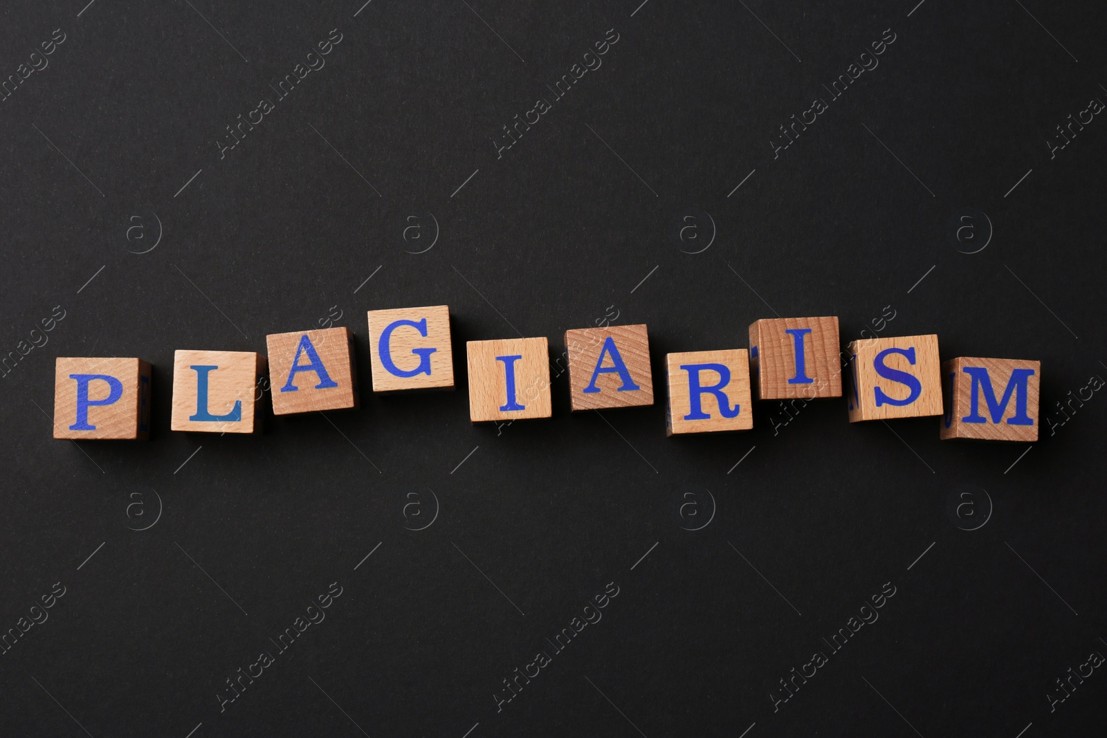 Photo of Wooden cubes with word Plagiarism on black background, flat lay