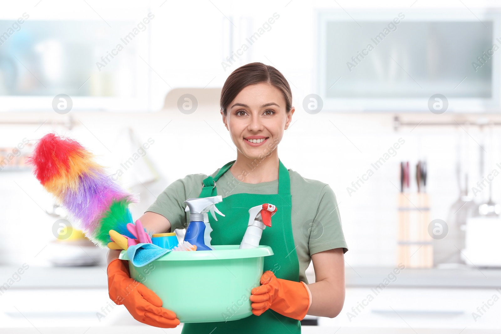 Photo of Woman in uniform with cleaning supplies indoors