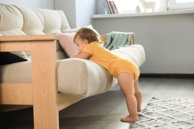 Photo of Cute baby learning to walk in living room