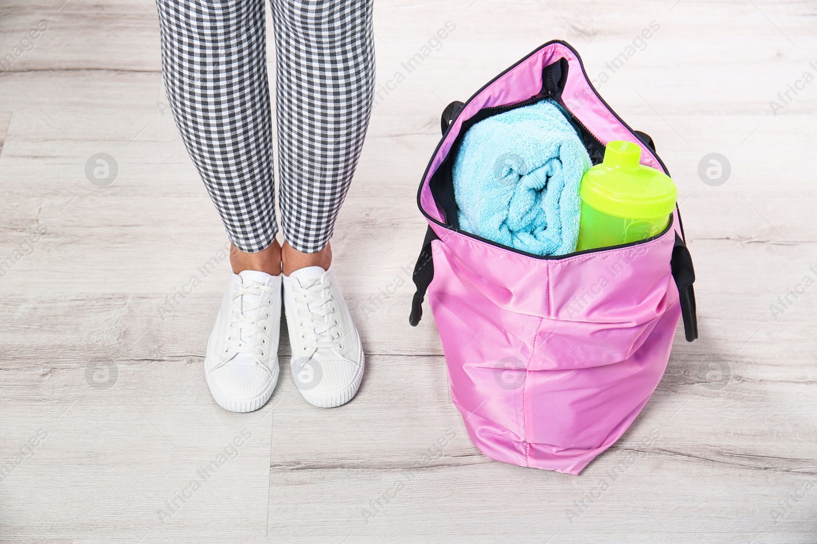 Photo of Young woman and sports bag with gym equipment, closeup. Ready for sport training