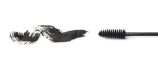 Photo of Applicator and black mascara smear for eyelashes on white background, top view