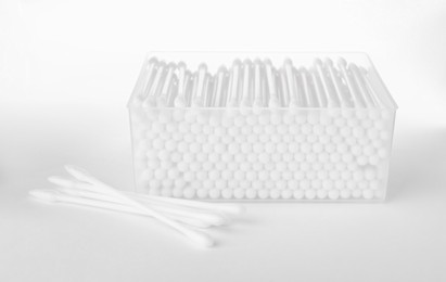 Photo of Cotton buds in plastic container isolated on white