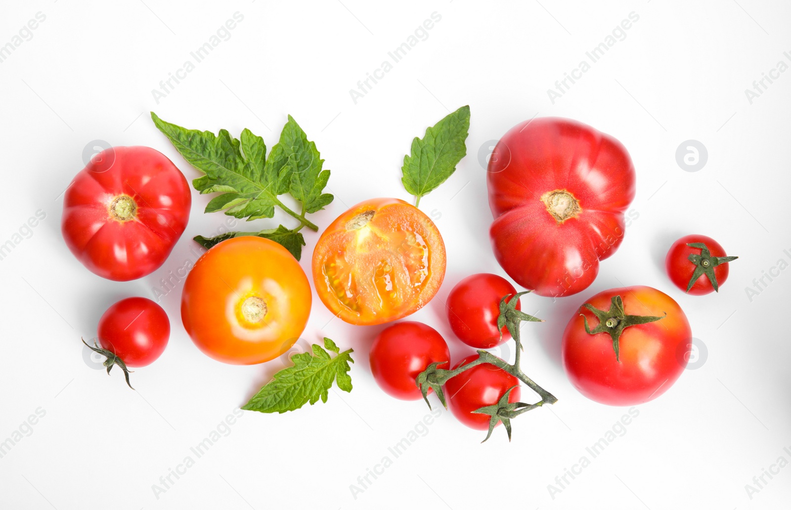 Photo of Many different ripe tomatoes and leaves on white background, flat lay