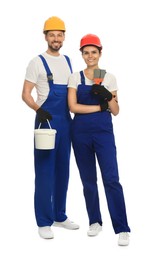 Photo of Professional workers with putty knives and plaster in hard hats on white background