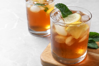 Photo of Delicious iced tea in glass on light grey marble table. Space for text