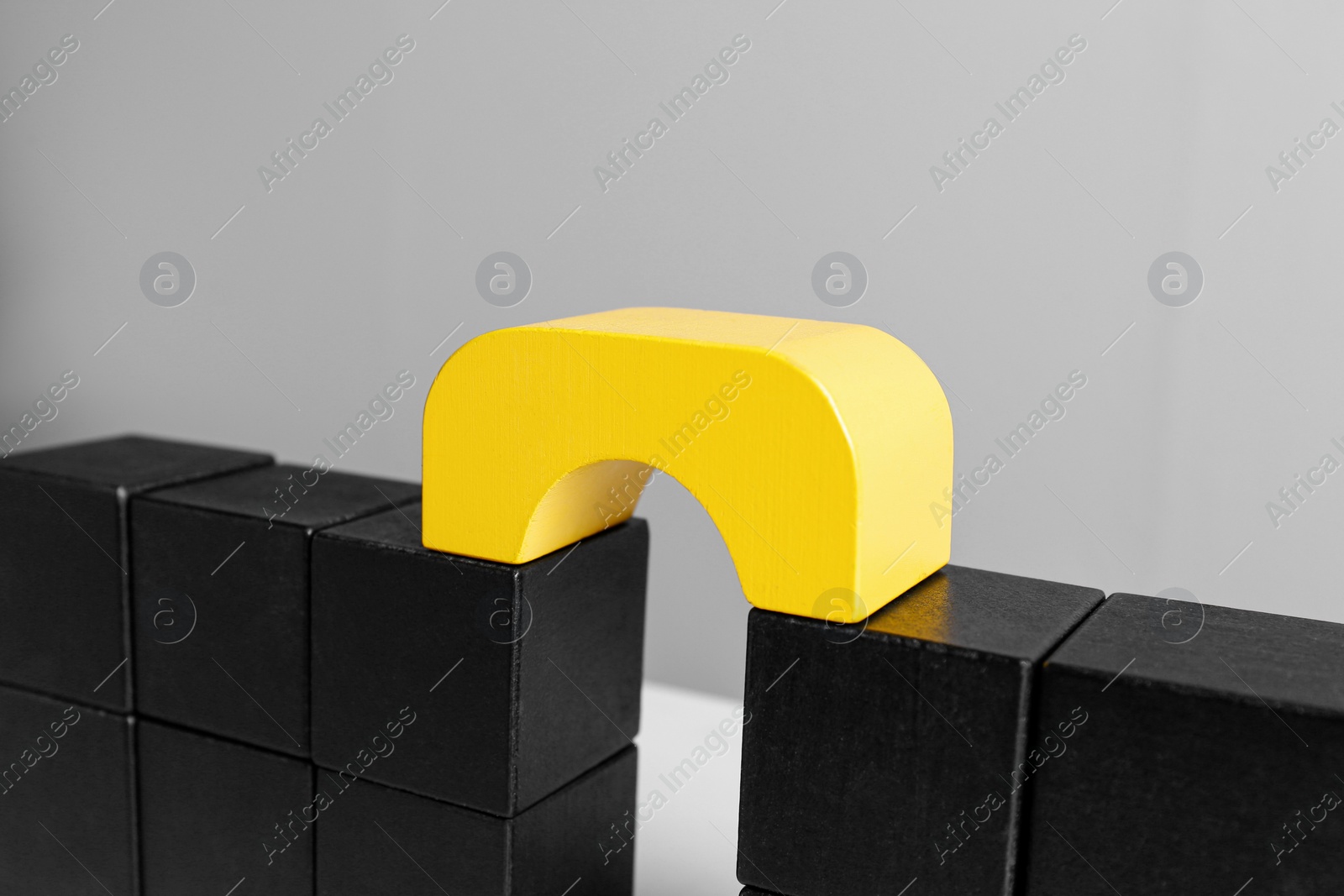 Photo of Bridge made of blocks on grey background, closeup. Connection, relationships and deal concept