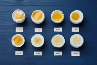 Different cooking time and readiness stages of boiled chicken eggs on blue wooden table, flat lay