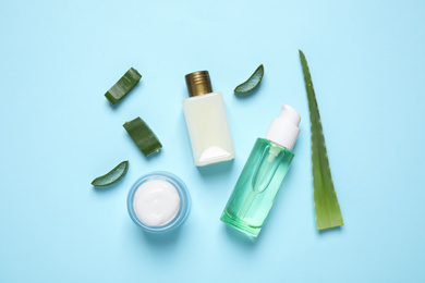 Photo of Flat lay composition with aloe vera and cosmetic products on light blue background