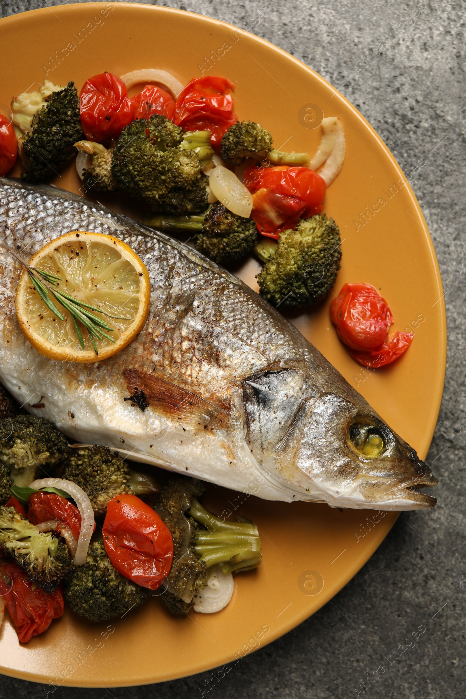 Photo of Delicious baked fish and vegetables on grey background, top view