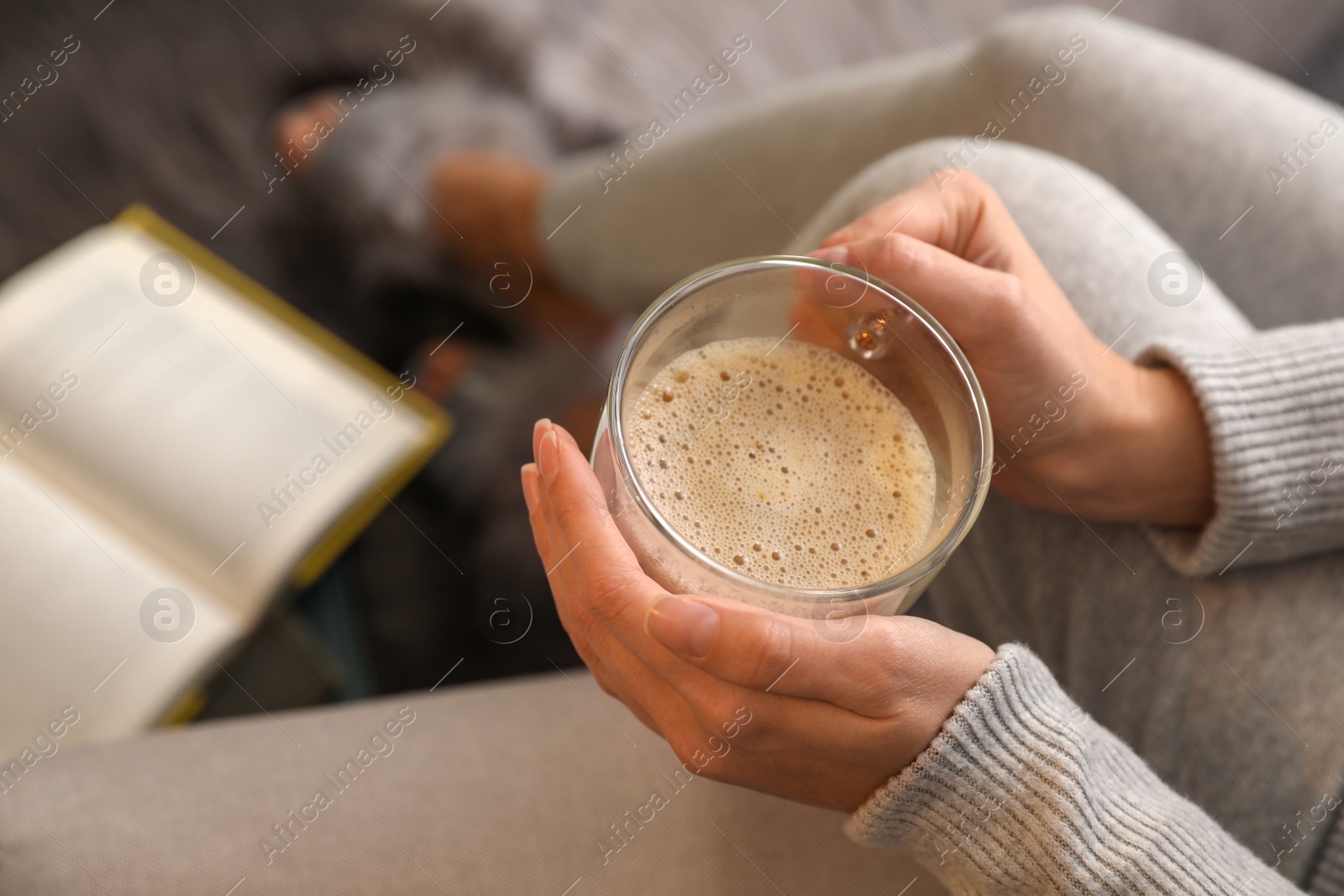 Photo of Woman with cup of hot coffee resting at home, above view
