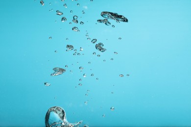 Air bubbles in water on light blue background