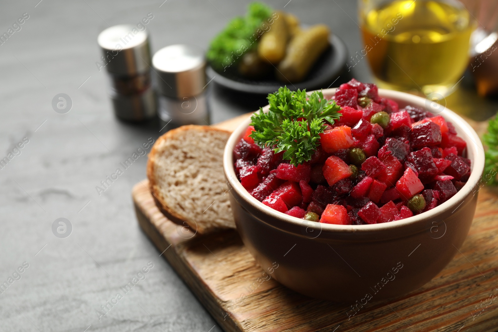 Photo of Traditional Russian salad vinaigrette served on grey table