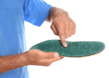 Photo of Male orthopedist showing insole on white background, closeup