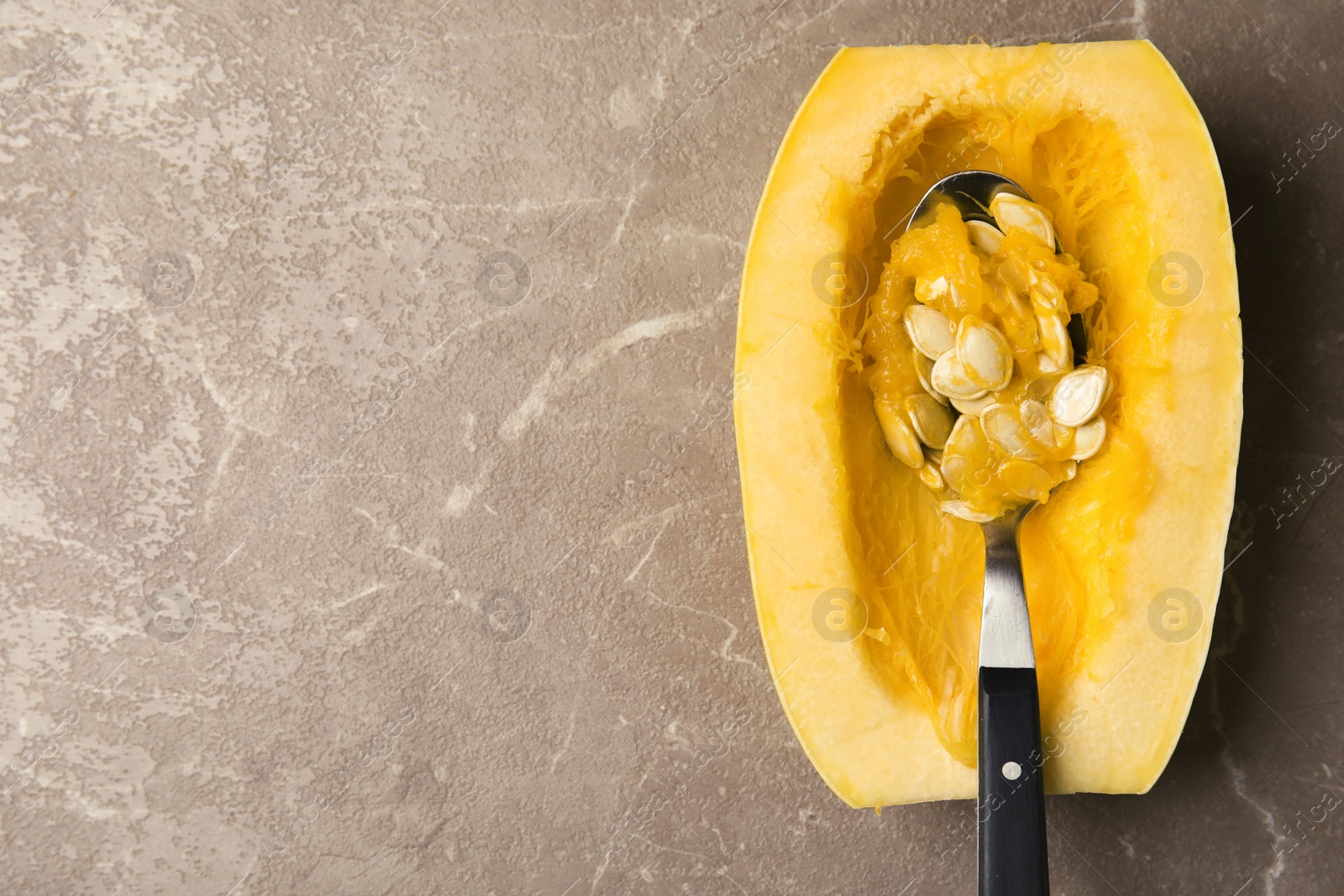 Photo of Cut spaghetti squash on gray table, top view. Space for text