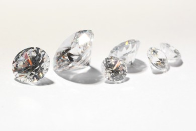 Photo of Many beautiful shiny diamonds on white background