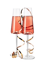 Glasses of rose champagne with gold streamer isolated on white