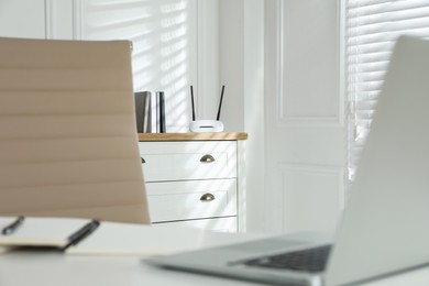 Photo of Modern wi-fi router on chest of drawers indoors