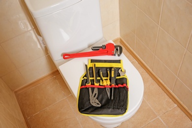 Photo of Different plumber's tools on toilet seat lid indoors